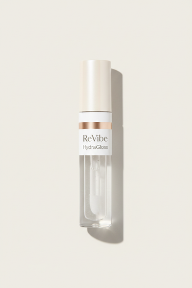 Hydrating Lip Gloss standing upright on #F4F0ED background, premium studio hero shot